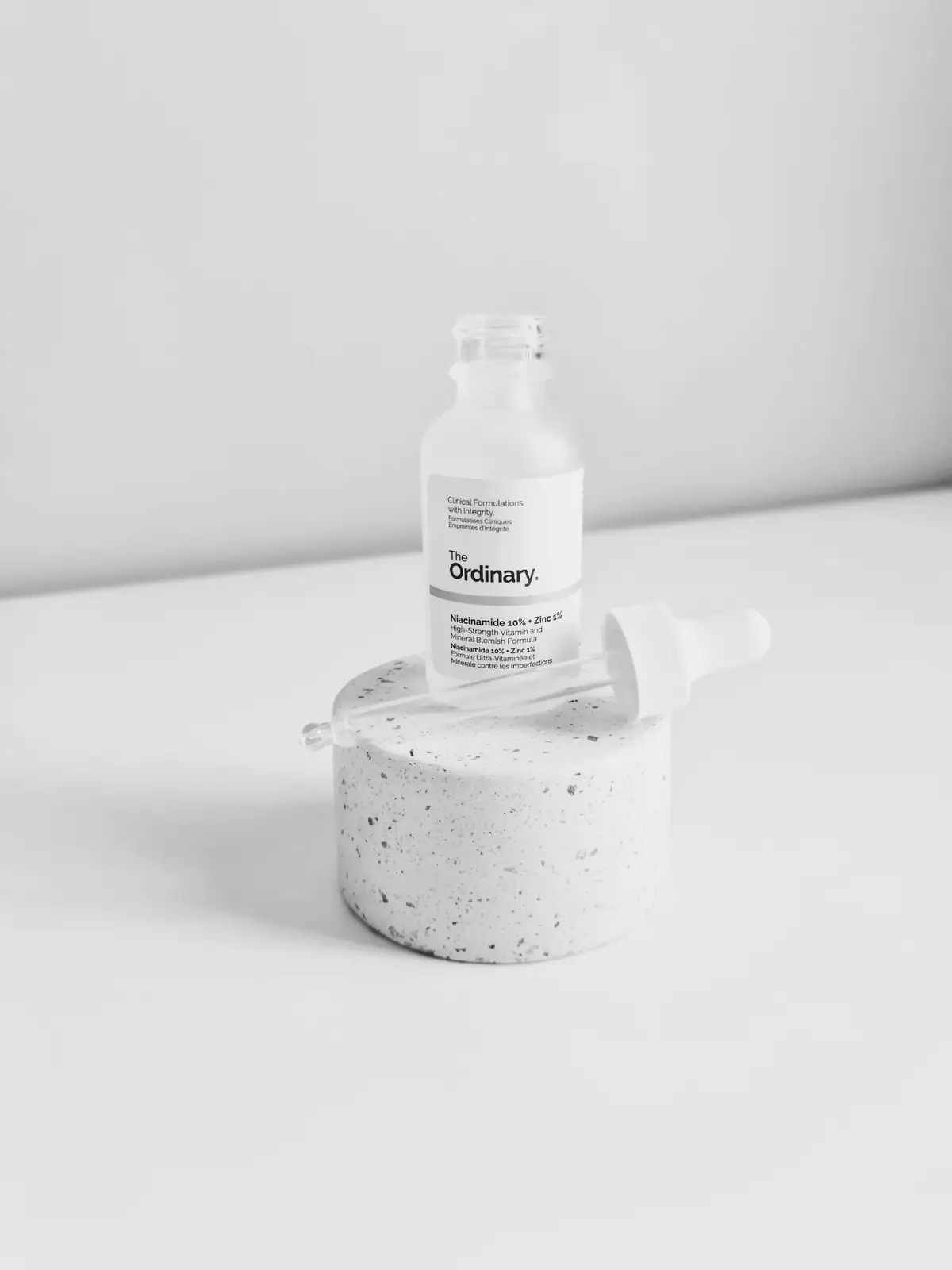 A small bottle on a stone plinth in white light