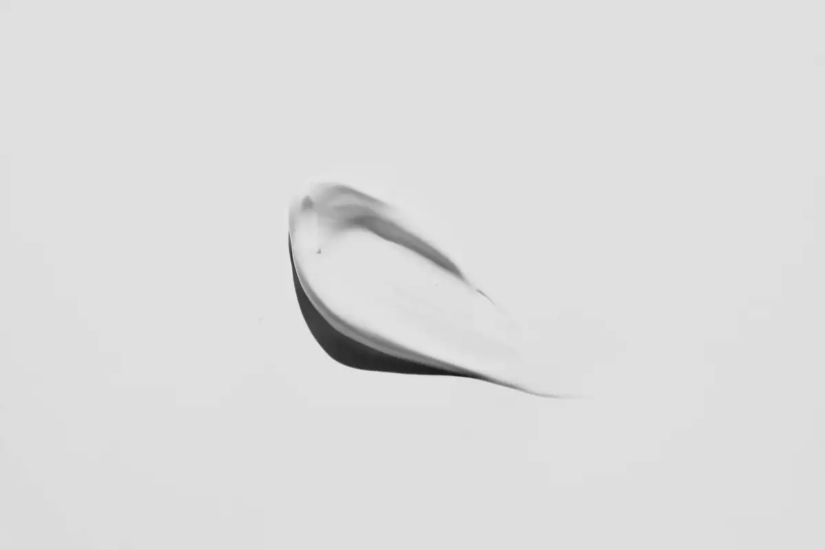 A single smear of white cream on a pale surface