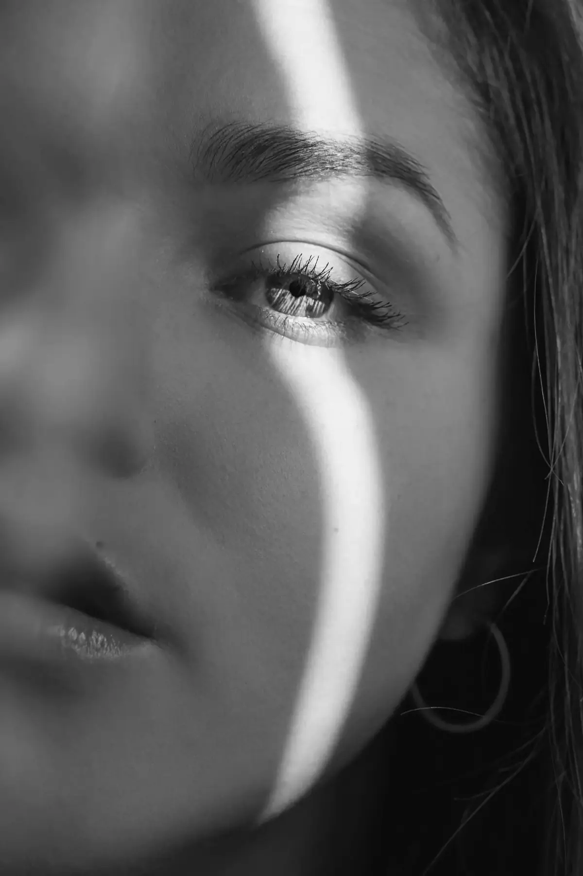 A woman's face in a narrow band of window light