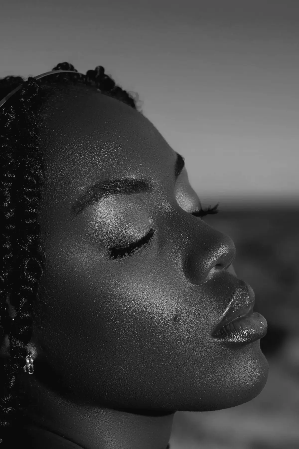 A woman in evening light, eyes closed, skin calm